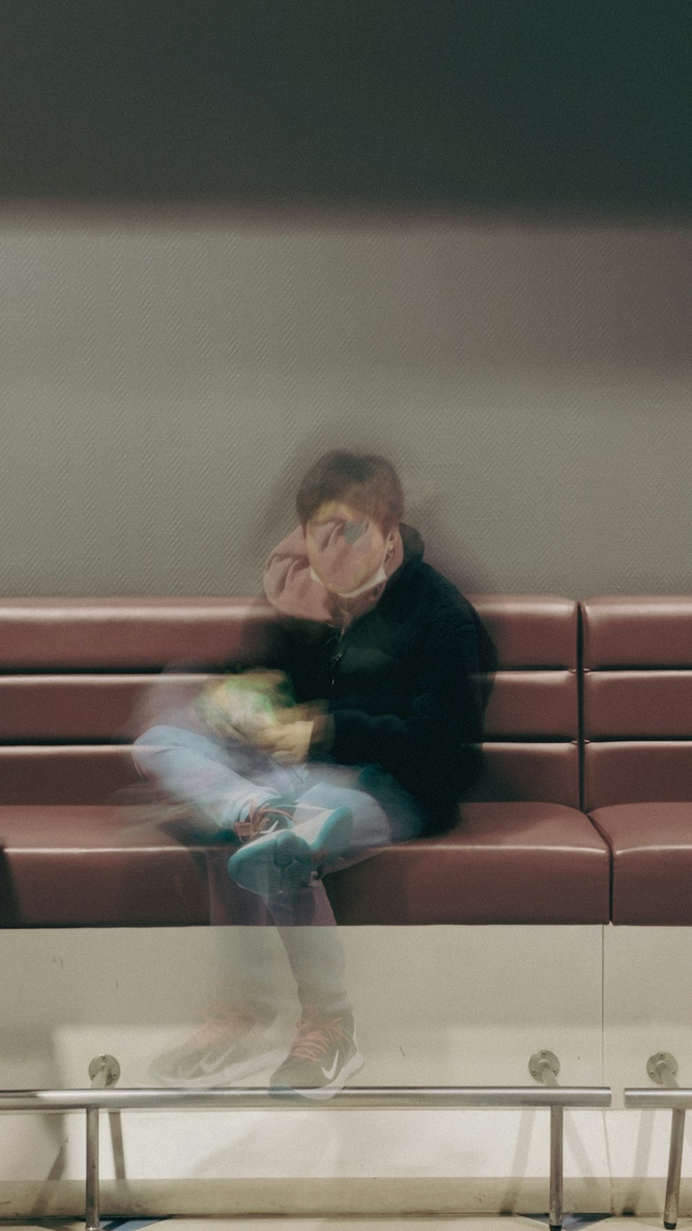 a man sitting on a bench in a waiting area