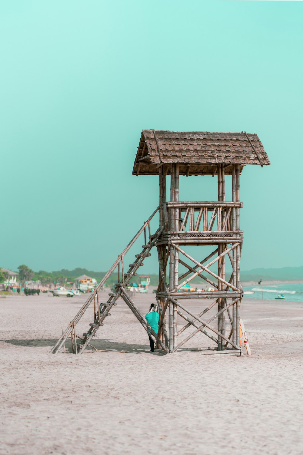 a lifeguard tower on the beach with a person standing on it
