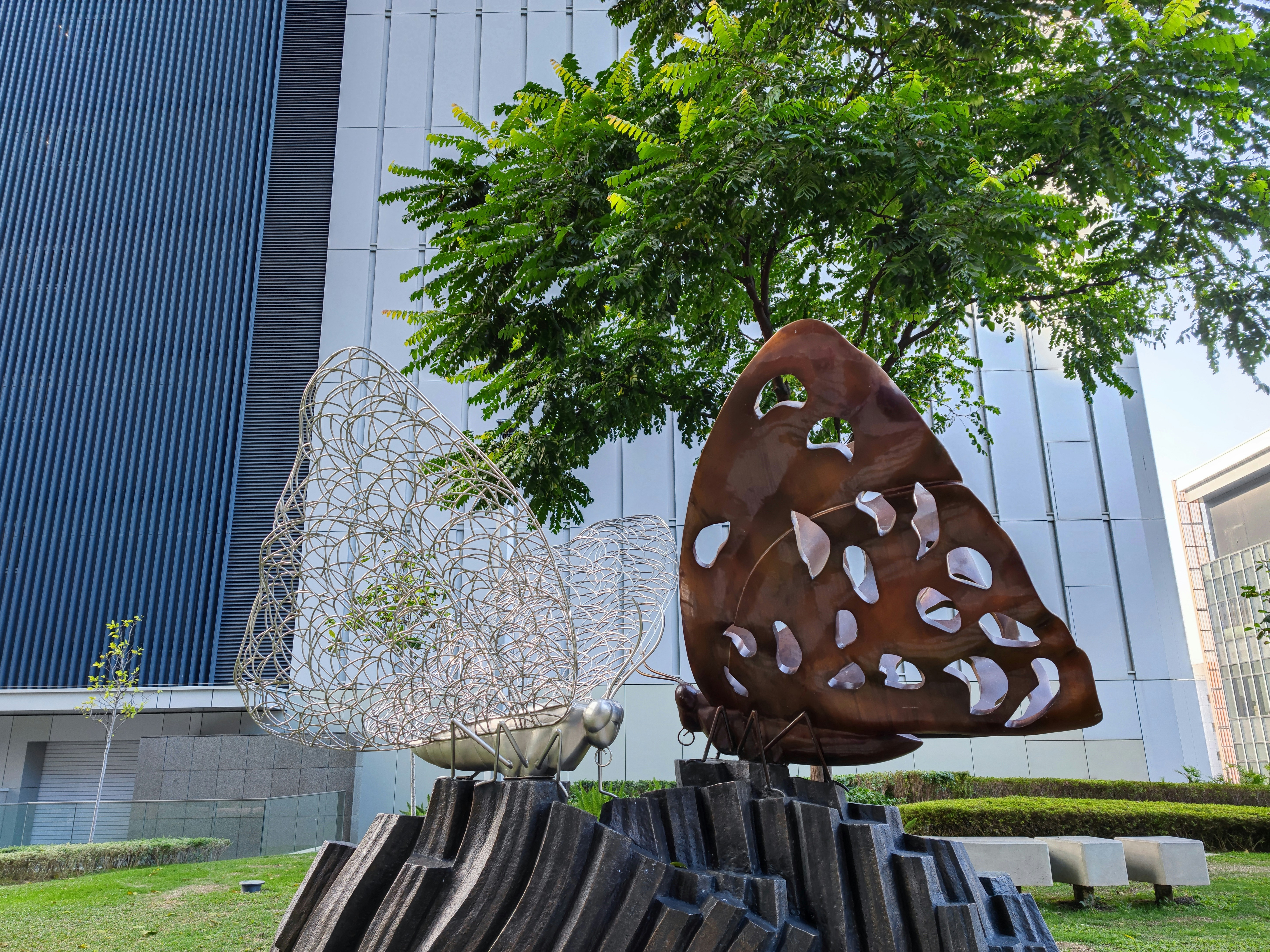 a sculpture of a butterfly and a bird on a tree stump