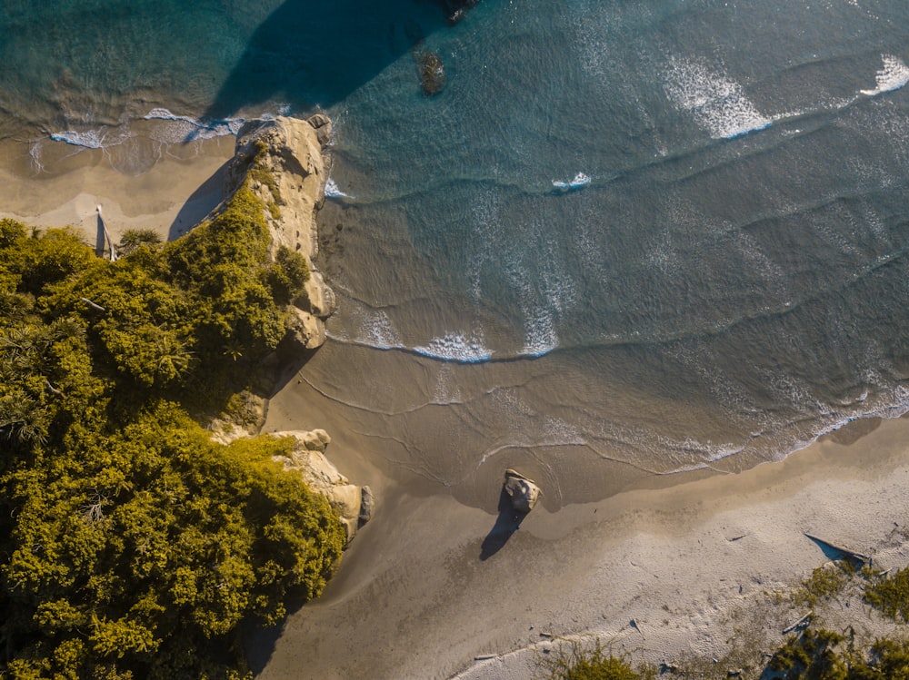 an aerial view of a beach with a boat in the water