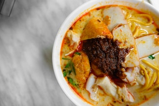 a bowl of noodles with meat and vegetables