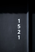 White numbers are vertically aligned on a dark gray textured wall, displaying the sequence 1, 5, 2, 1.