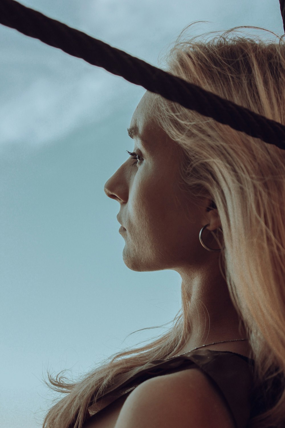 a woman with long blonde hair is looking off into the distance