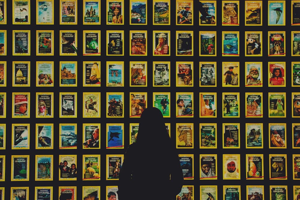 a person standing in front of a wall of movie posters