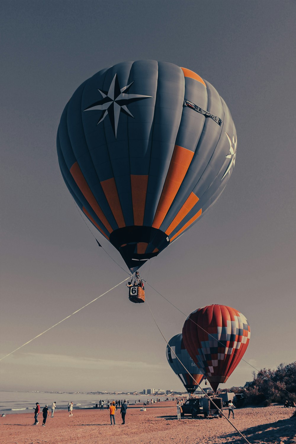 a couple of hot air balloons flying over a beach