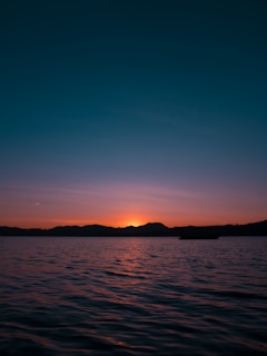 the sun is setting over a body of water