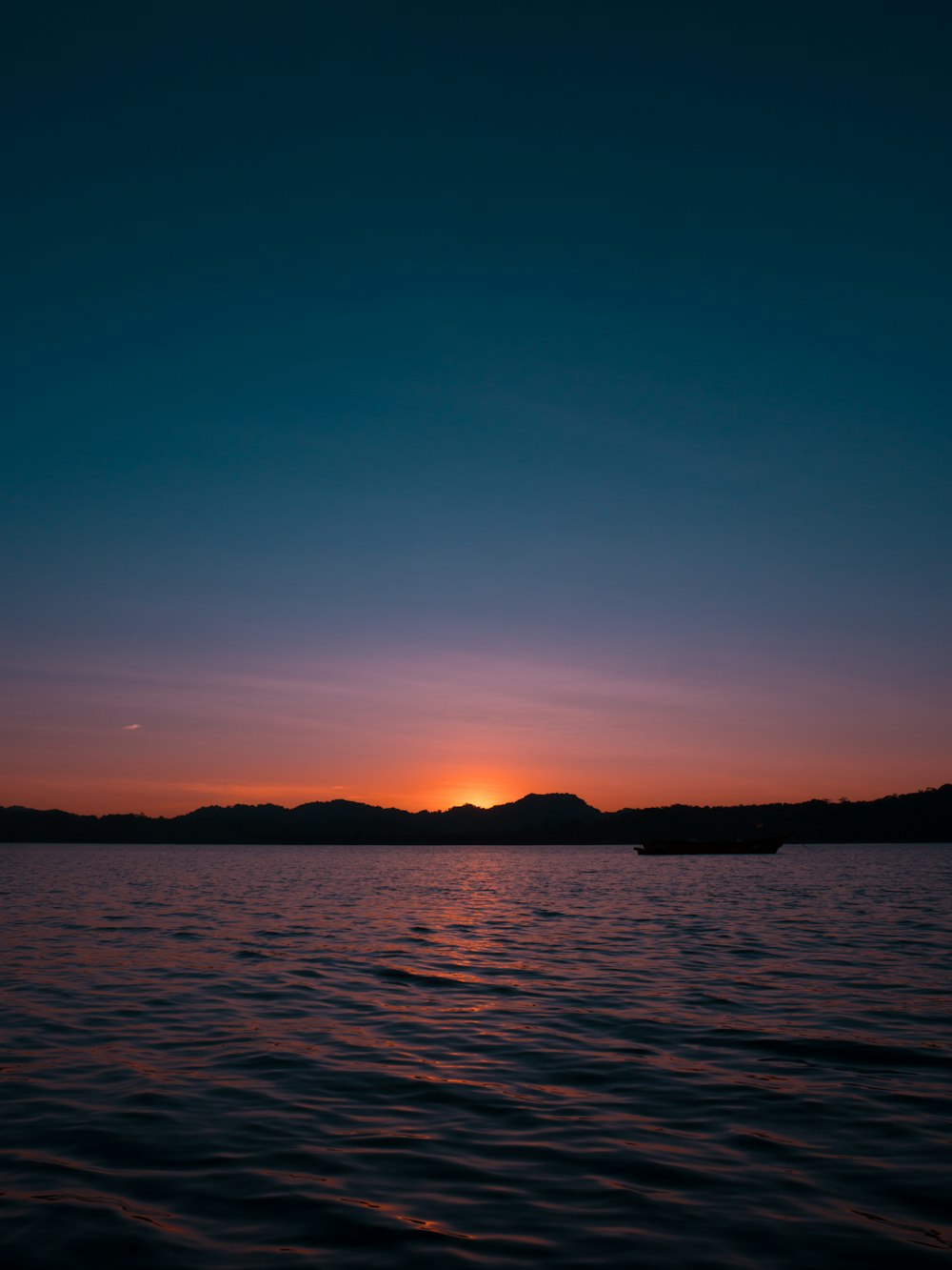 Il sole sta tramontando su uno specchio d'acqua