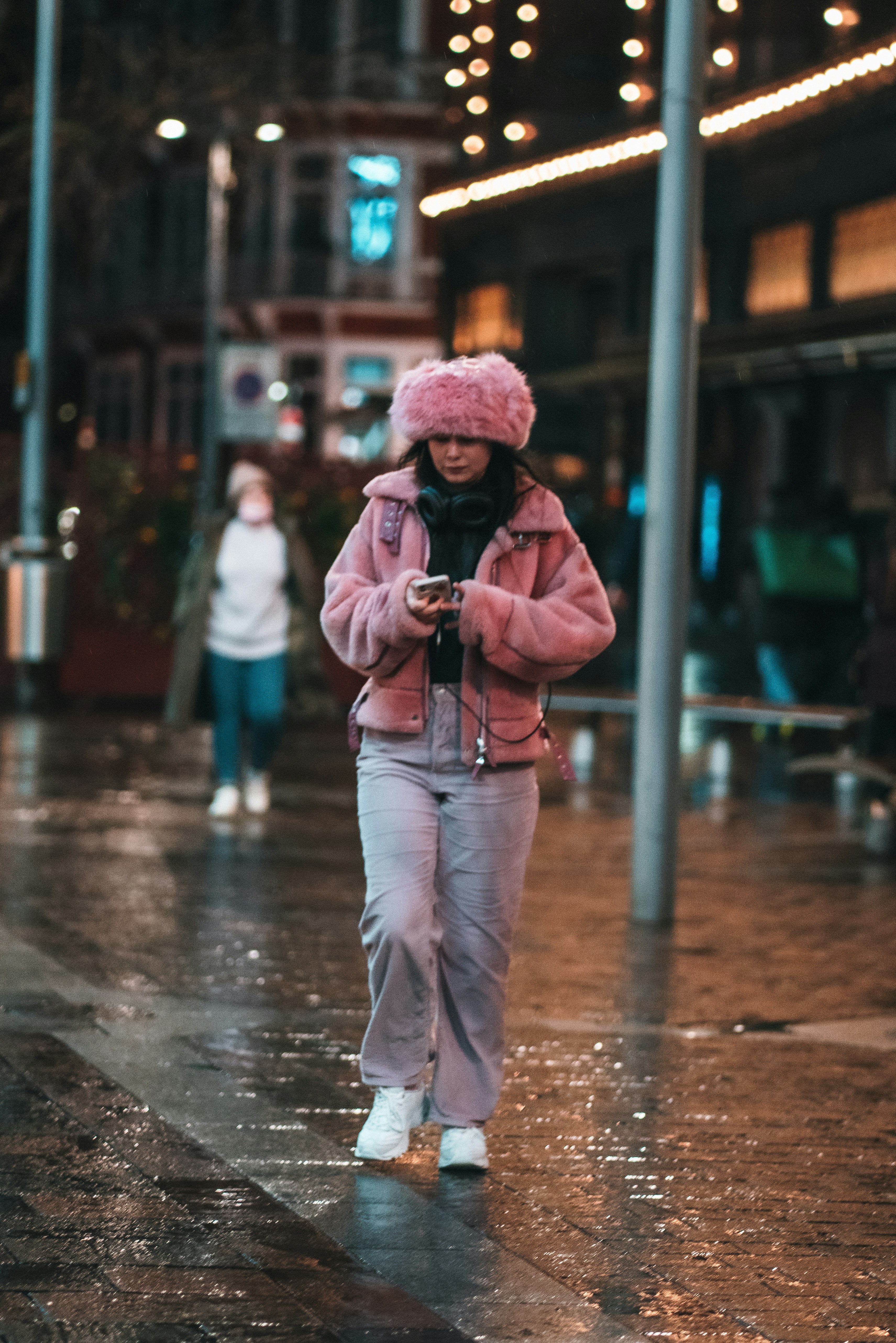 a woman walking down a street in the rain