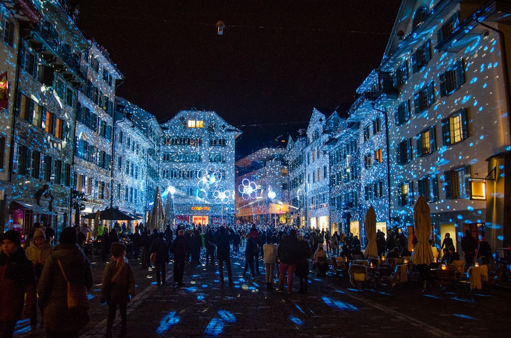 a group of people walking down a street at night