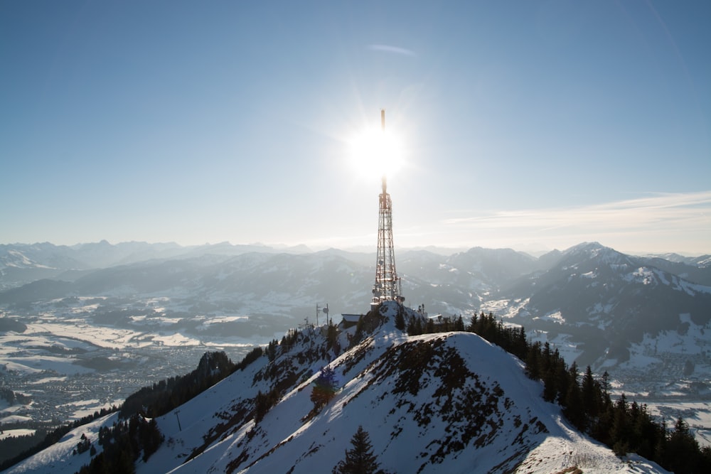 a very tall tower sitting on top of a snow covered mountain