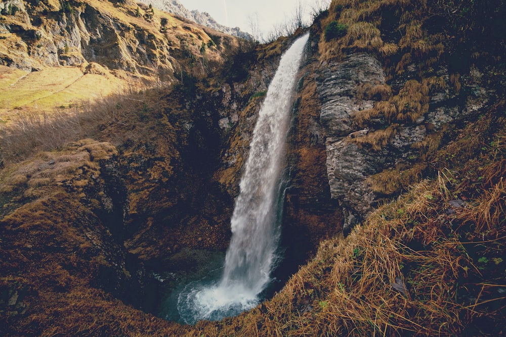 a large waterfall in the middle of a mountain