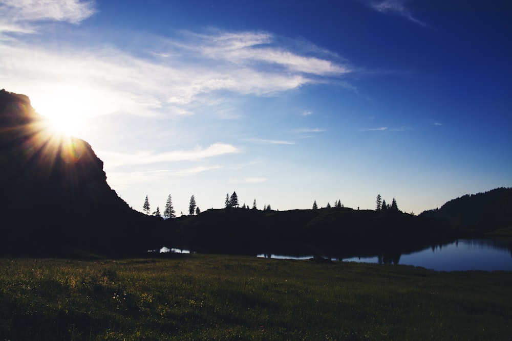 the sun is shining over a mountain and a lake