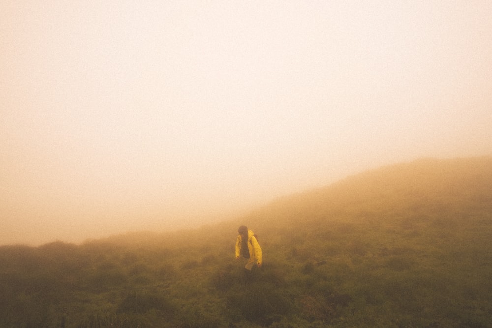 a person walking up a hill on a foggy day