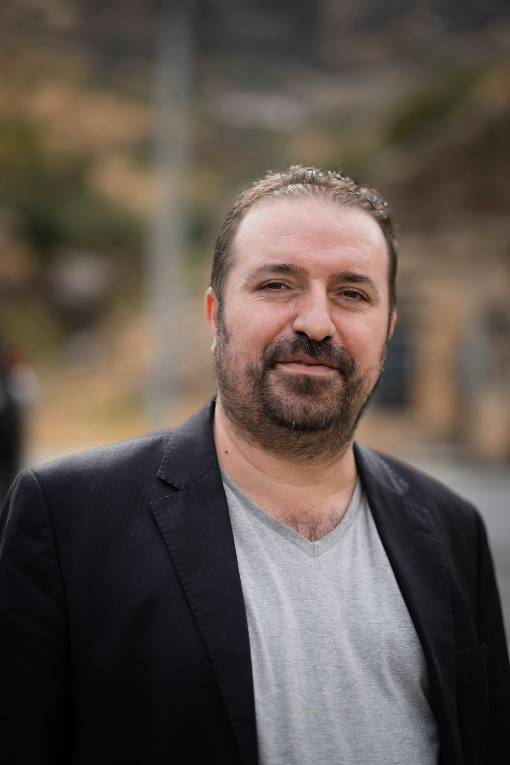 Un homme avec une barbe portant une veste noire