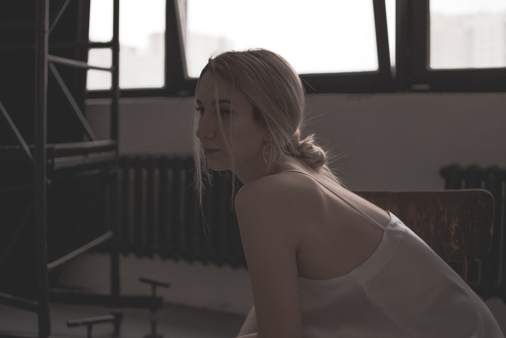 a woman sitting on a chair in front of a window