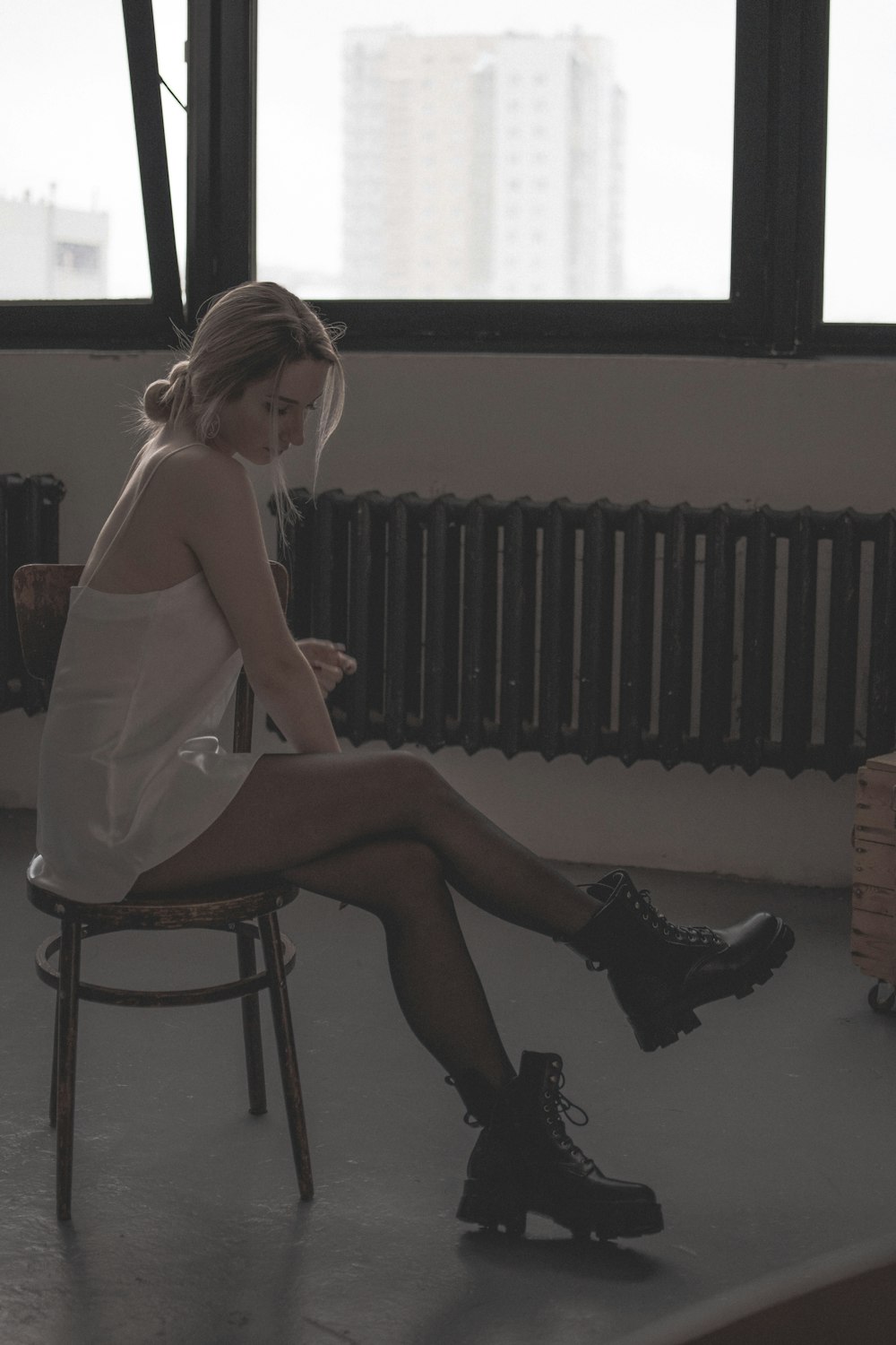 a woman sitting in a chair looking at her phone