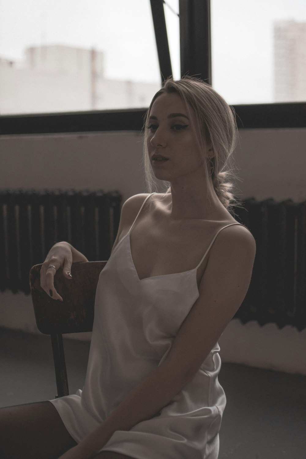 a woman in a white dress sitting on a chair