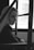 a black and white photo of a woman sitting in a bus