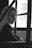 a black and white photo of a woman sitting in a bus