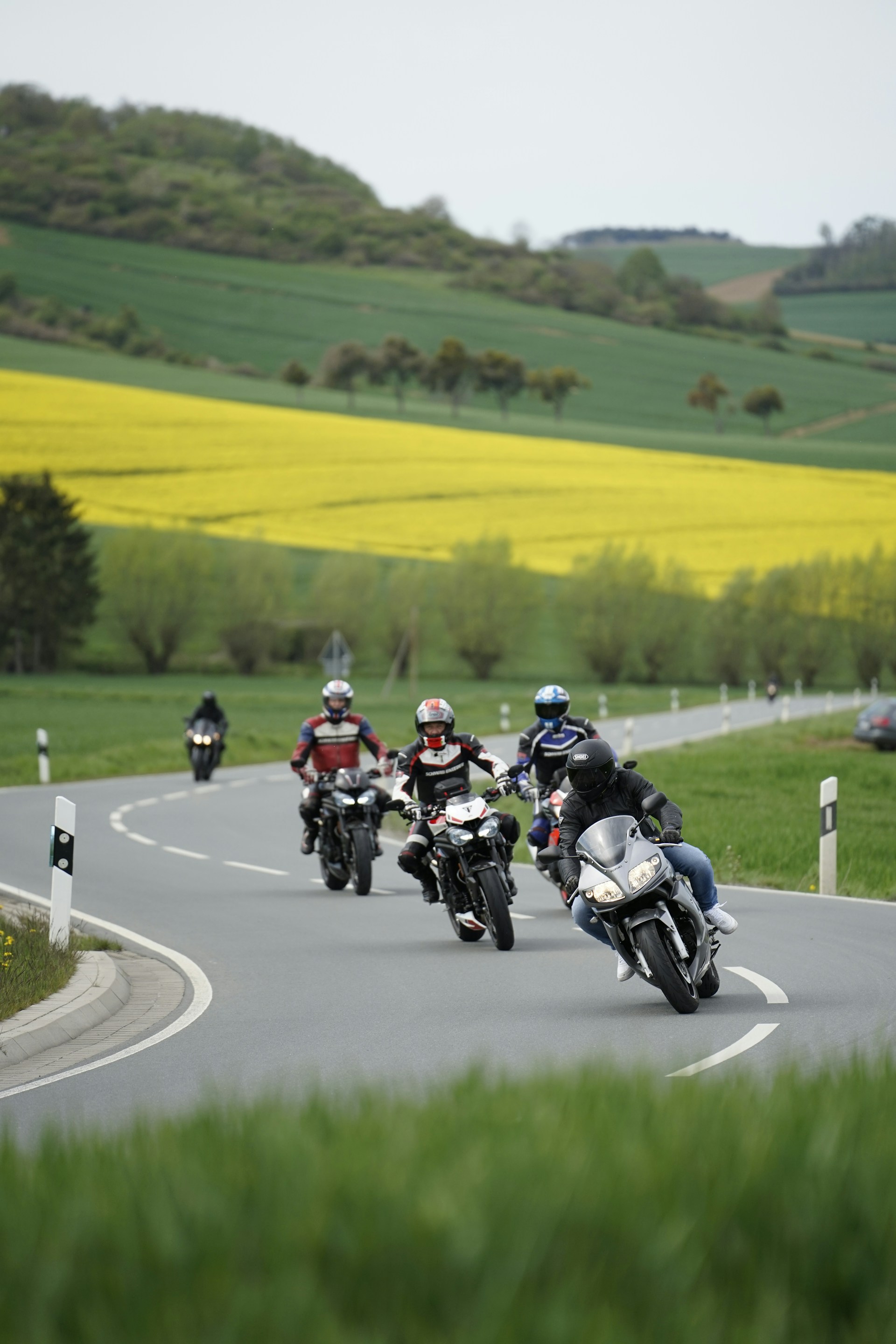 a group of people riding motorcycles down a curvy road