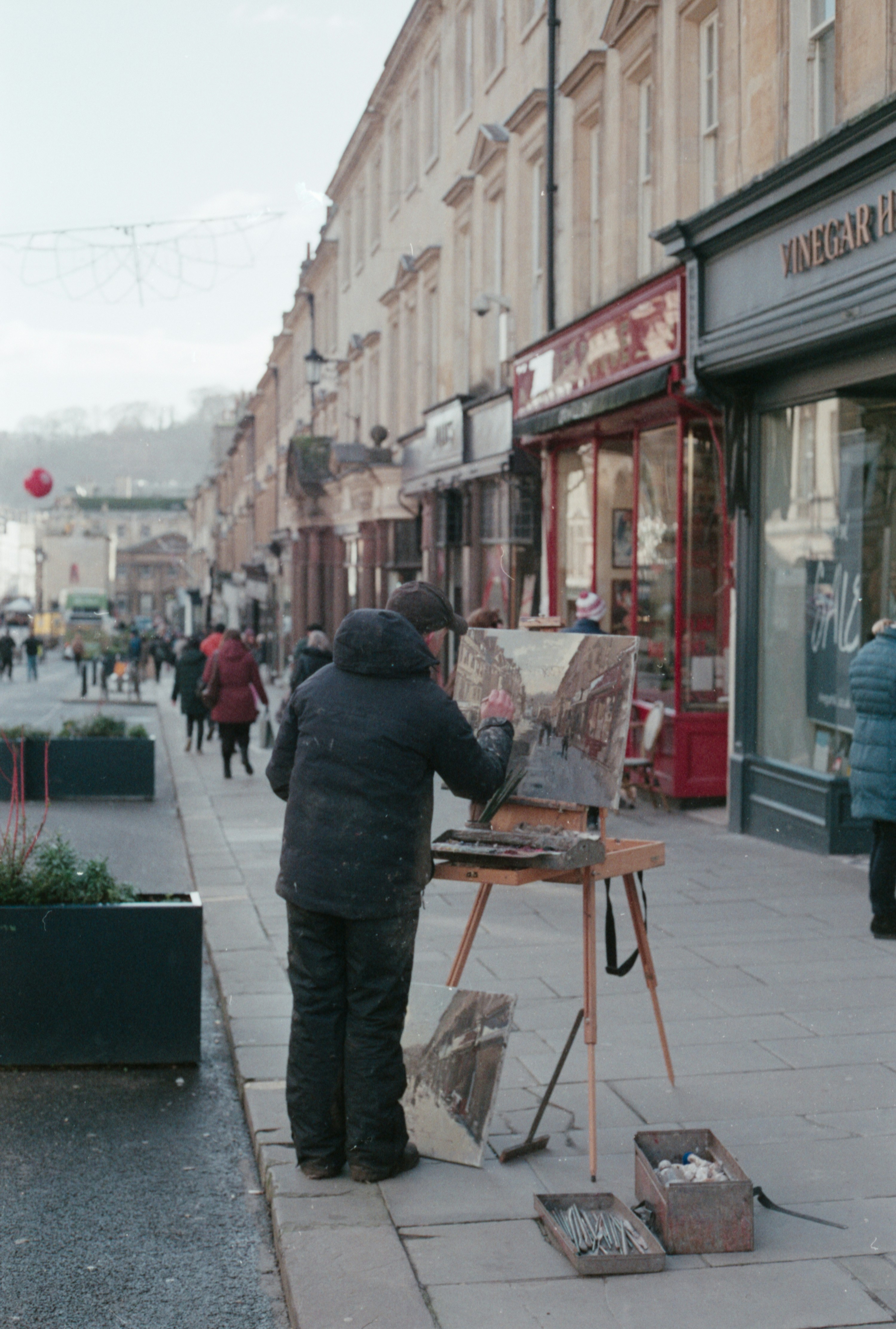 a person painting on a sidewalk in front of a building