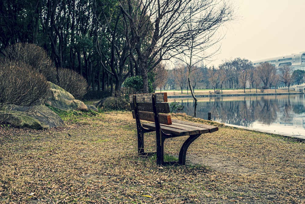 a wooden bench sitting on top of a grass covered field