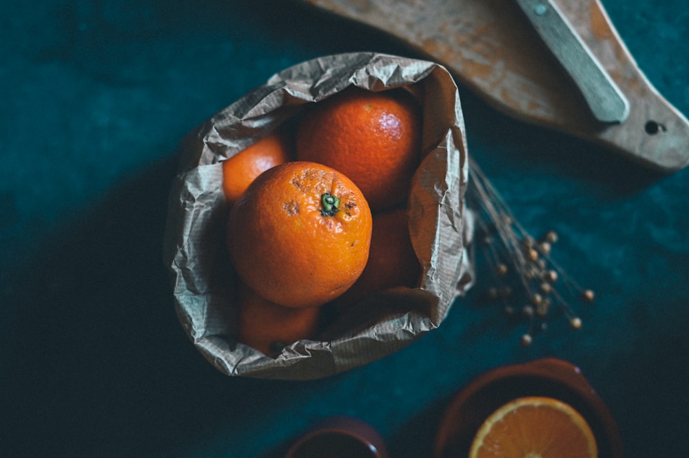 a bowl of oranges sitting on top of a table