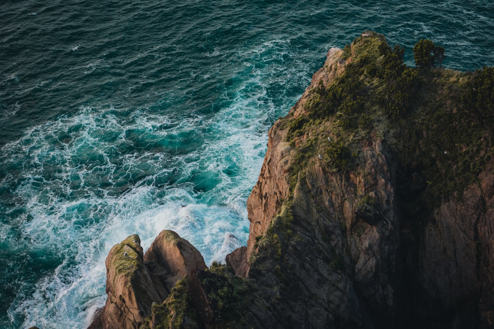 an aerial view of the ocean and rocks