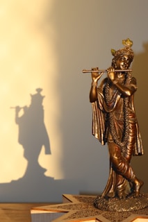 a bronze statue of a man playing a flute