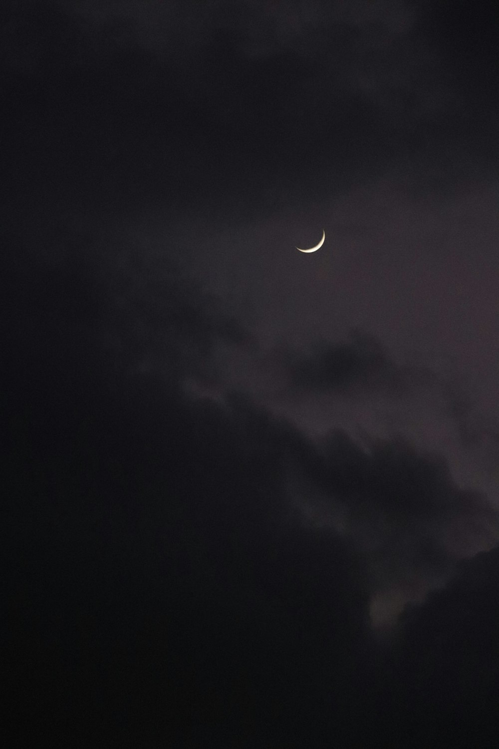 the moon is seen through the clouds in the night sky