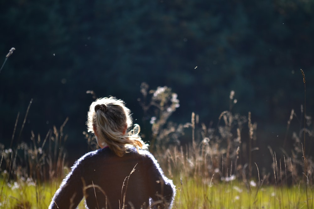 a woman standing in a field of tall grass