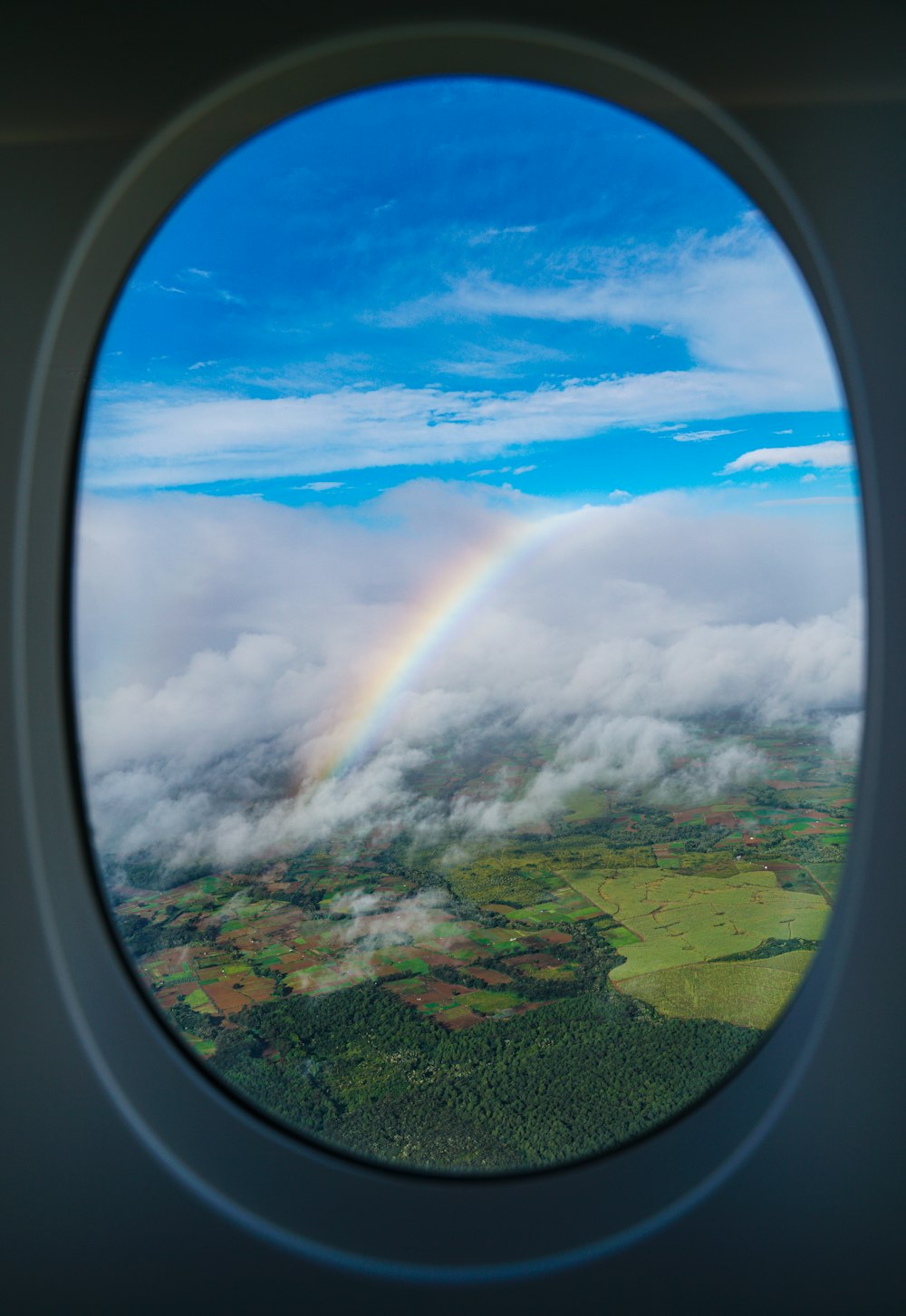 uma vista de um arco-íris através de uma janela de avião