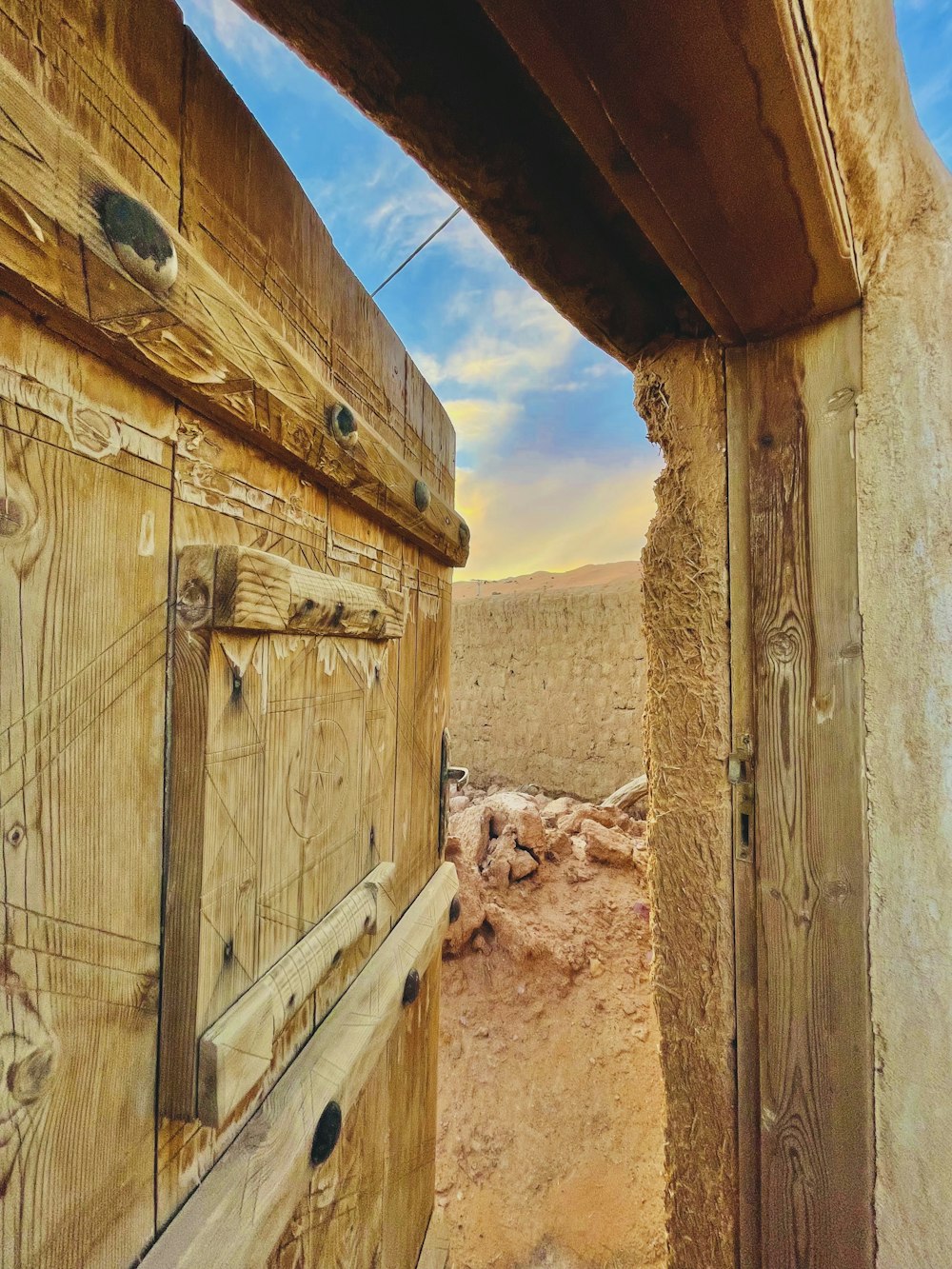 a wooden door leading to a desert landscape