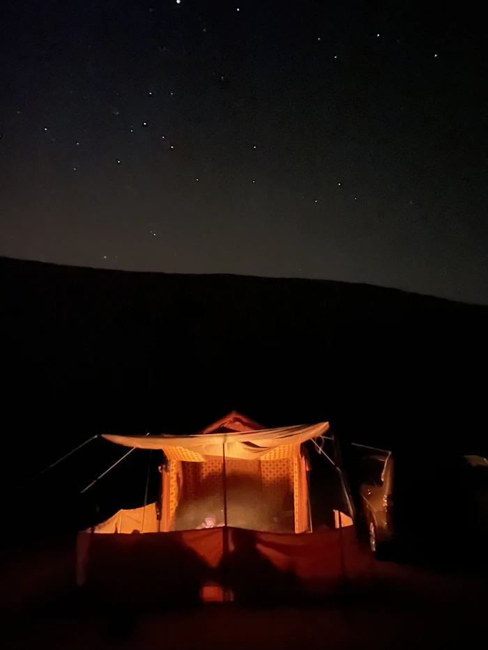 Bivouac nomade illuminé sous un ciel étoilé dans le désert