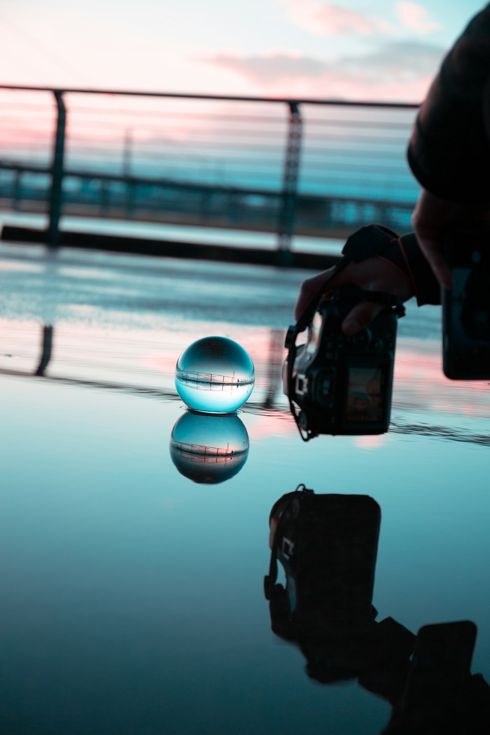 a person holding a camera taking a picture of a ball