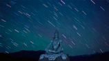 A peaceful depiction of Lord Shiva meditating by the river under a starry night sky