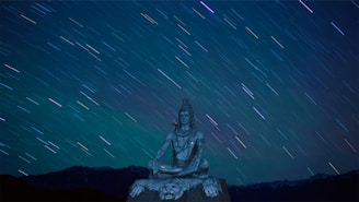 A serene image of a person meditating under a starry sky, surrounded by astrological symbols.