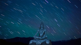A serene figure meditating under a swirling galaxy sky.