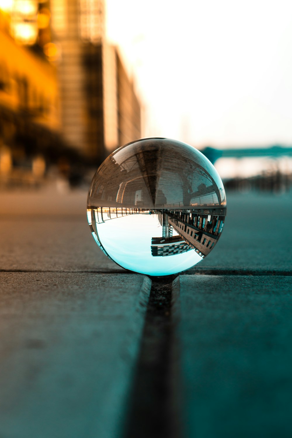 a glass ball sitting on the side of a road