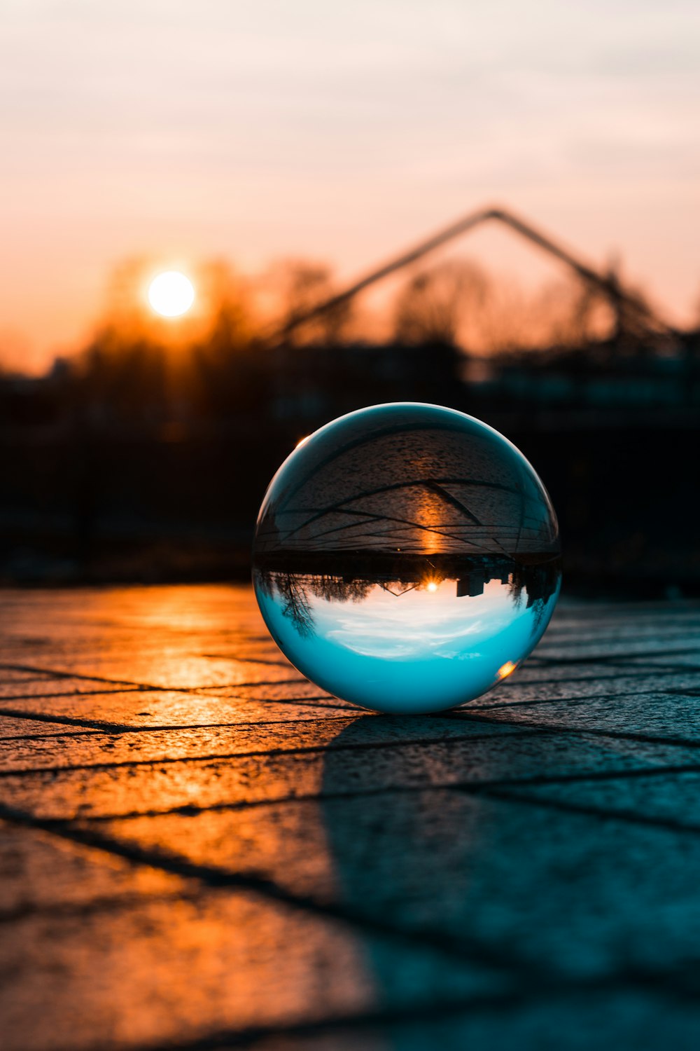 a glass ball sitting on top of a sidewalk