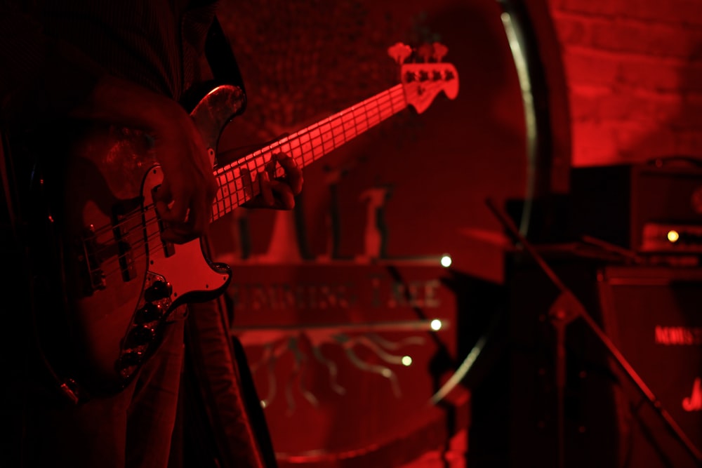 Eine Person, die in einem dunklen Raum Gitarre spielt