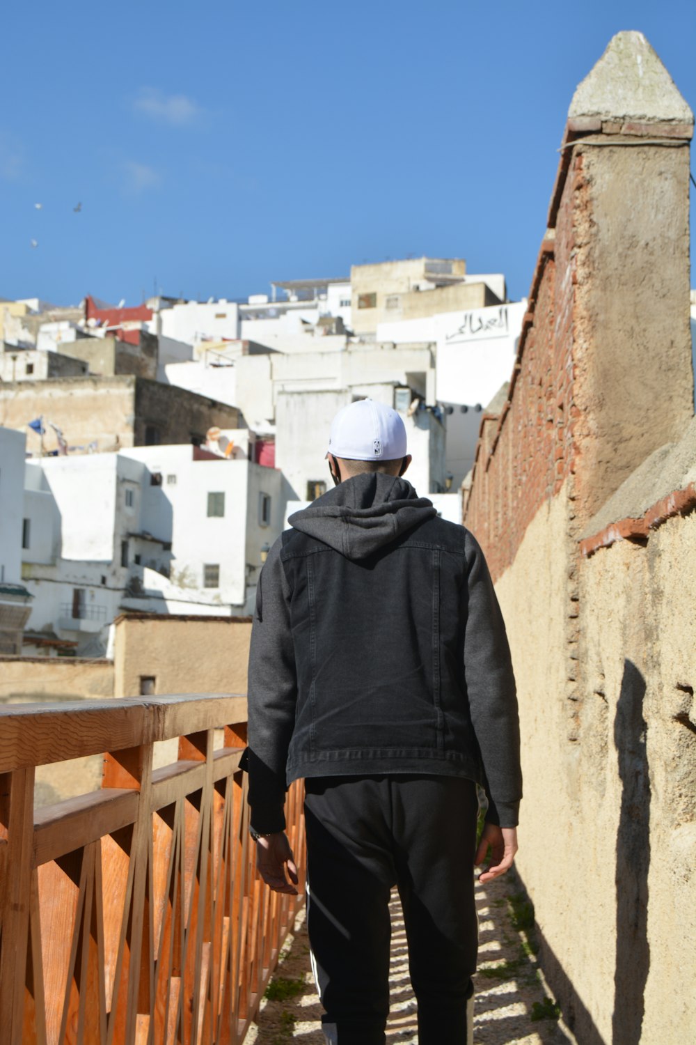 a man in a black jacket is walking down a path