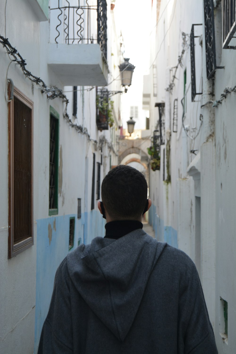 a man walking down a narrow alley way