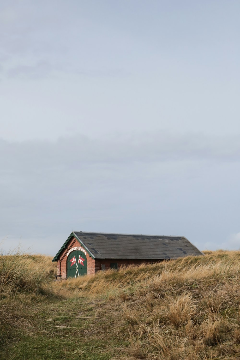 a small building in the middle of a grassy field