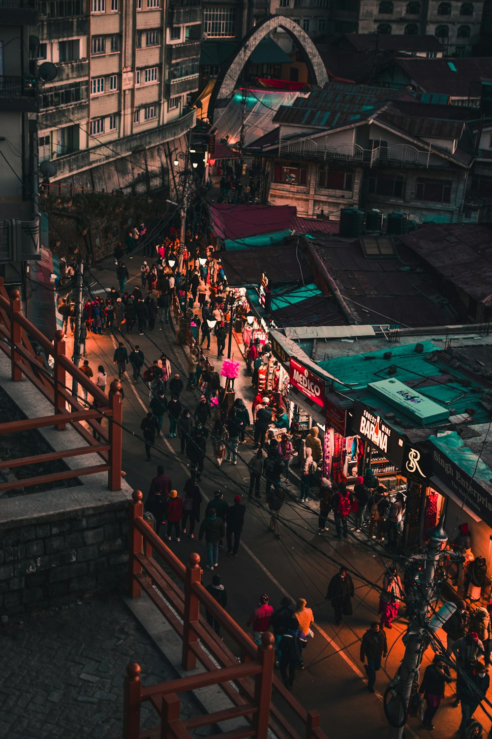 a crowd of people walking down a street next to tall buildings