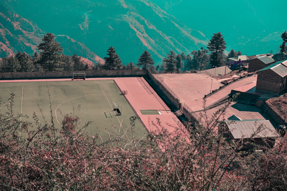 an aerial view of a tennis court surrounded by mountains