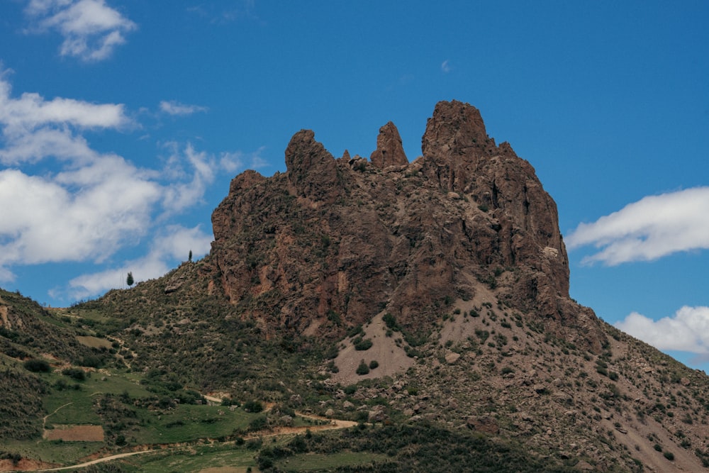 a very tall mountain with a few clouds in the sky