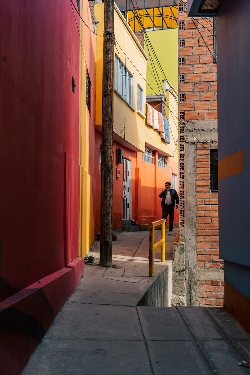 a man walking down a street next to tall buildings