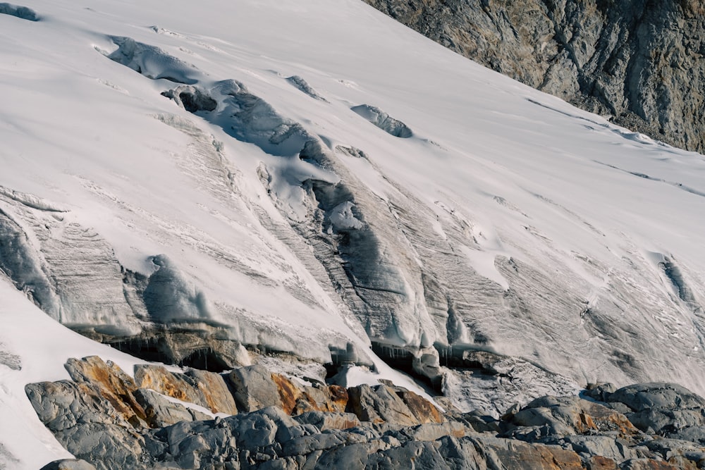 a snow covered mountain with rocks and snow