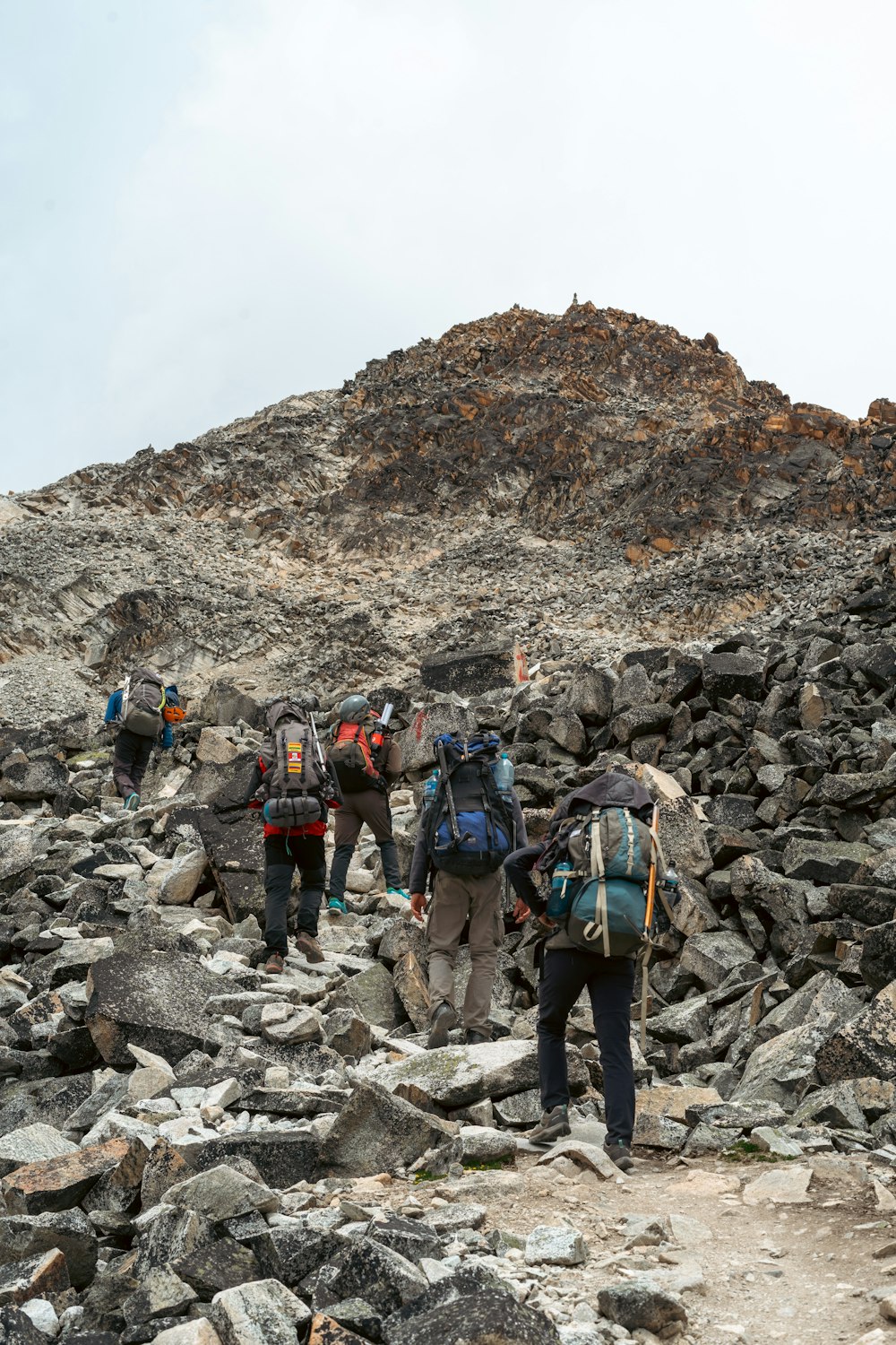 a group of people hiking up a rocky hill